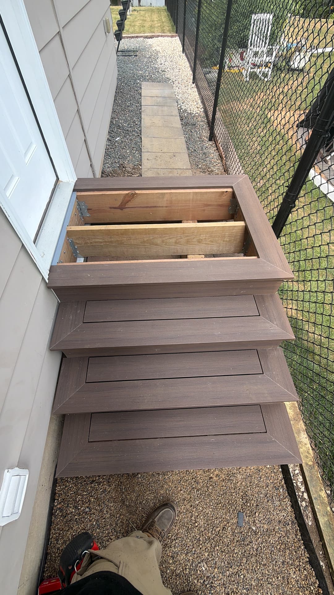 New composite entry stairs and landing framed over a side yard walkway